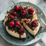 Delicious slice of No Bake Black Forest Cheesecake with dark crust and fresh cherries.