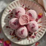 Delicious Raspberry Rose Truffles with a creamy pink center and powdered sugar coating.